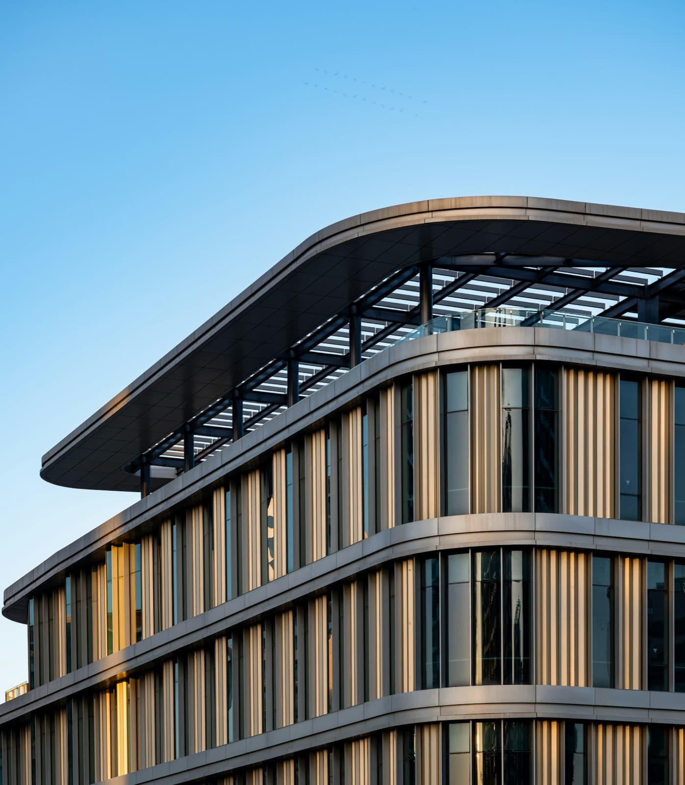 The upper floors of a modern office building against a clear sky